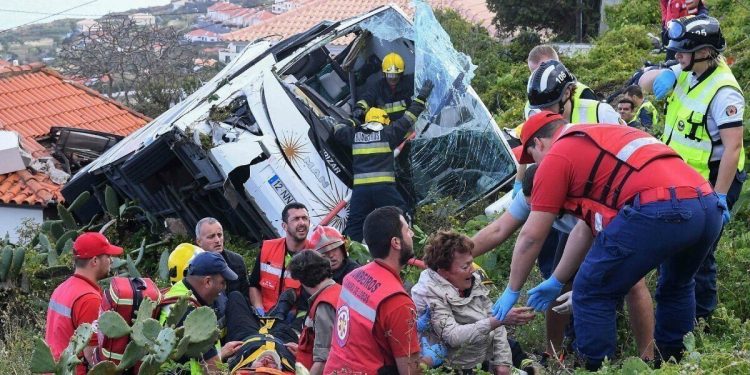 Firemen help victims of a tourist bus that crashed on April 17, 2019 in CaniÁo, on the Portuguese island of Madeira. - At least 28 people were killed when a tourist bus crashed on the Portuguese island of Madeira, the local mayor told local media. The regional protection service did not confirm the toll when questioned by AFP. (Photo by RUI SILVA / AFP)