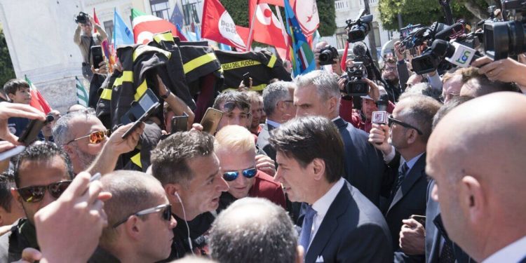 Il premier Giuseppe Conte con i Vigili del fuoco in protesta (LaPresse)