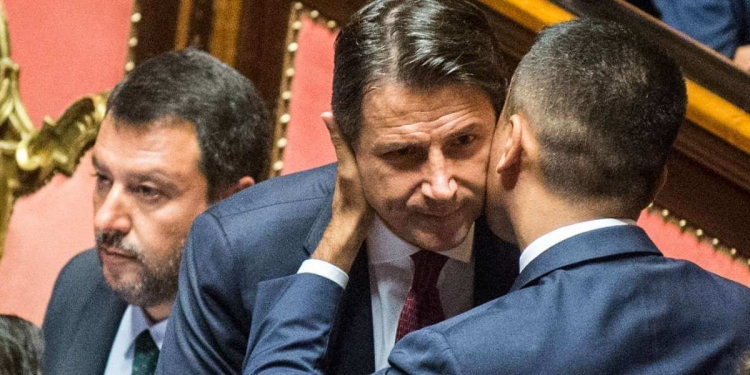 Luigi Di Maio abbraccia Giuseppe Conte; dietro, Matteo Salvini (LaPresse)