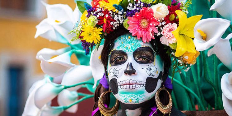 Guanajuato, Mexico - January 12, 2019: Portrait of a woman with beautiful Day of the Dead themed costumes and skull makeup on the streets of Guanajuato, Mexico.