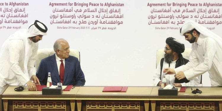 U.S. peace envoy Zalmay Khalilzad, left, and Mullah Abdul Ghani Baradar, the Taliban group's top political leader sign a peace agreement between Taliban and U.S. officials in Doha, Qatar, Saturday, Feb. 29, 2020. The United States is poised to sign a peace agreement with Taliban militants on Saturday aimed at bringing an end to 18 years of bloodshed in Afghanistan and allowing U.S. troops to return home from America's longest war. (AP Photo/Hussein Sayed)