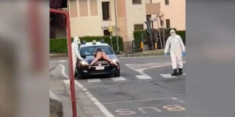 Donna nuda si sdraia su auto carabinieri