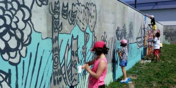 I bambini della scuola Il Pellicano dipingono il murales