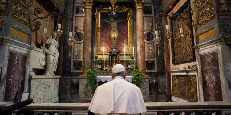 Papa Francesco prega in ginocchio davanti al crocifisso nella chiesa di San Marcello