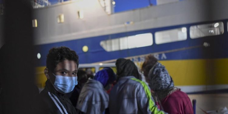 Immigrati si imbarcano a Lampedusa su una nave per la quarantena anti-Covid (LaPresse)