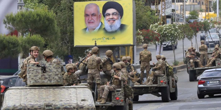 Forze dell'esercito libanese davanti al manifesto di Hezbollah Hassan Nasrallah, a destra, e del capo del blocco parlamentare Mohammed Raad (LaPresse)