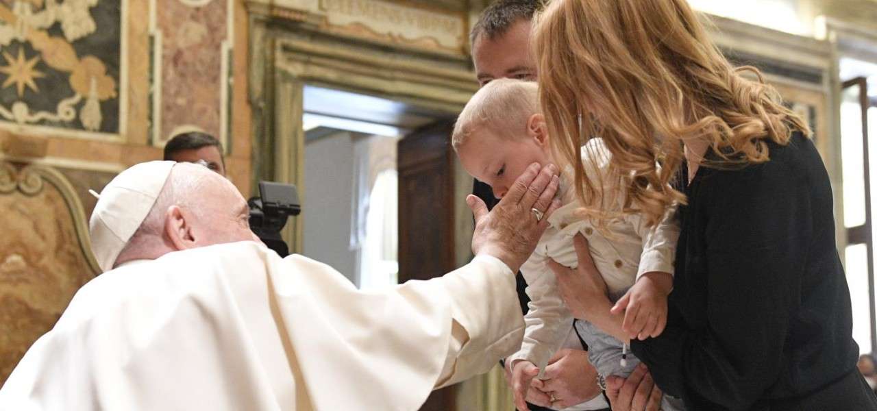Papa Francesco con una giovane famiglia (LaPresse)