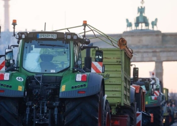 Trattori a Berlino, davanti alla Porta di Brandeburgo (Ansa)