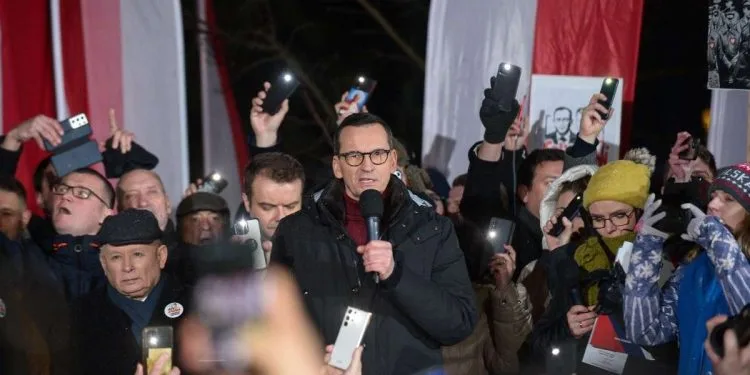 Protesta davanti al parlamento in Polonia. Al centro l'ex premier Morawiecki, a sin. si riconosce Jaroslaw Kaczynski (Ansa)