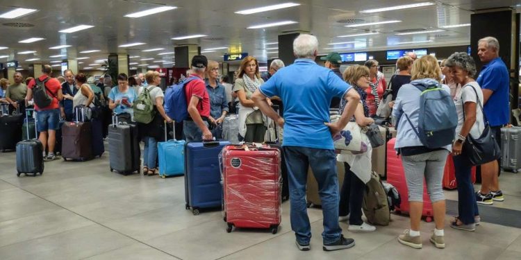 Viaggiatori all'aeroporto di Linate (Ansa)