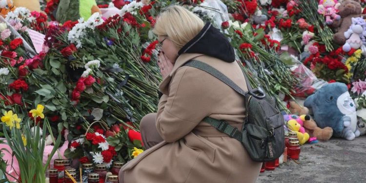 Donna in preghiera per le vittime dell'attentato alla Crocus City Hall (Ansa)