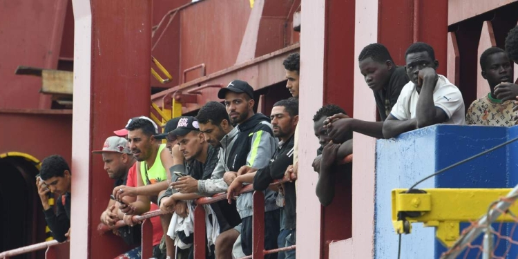 Migranti vengono fatti sbarcare da un mercantile a Salerno (Ansa)