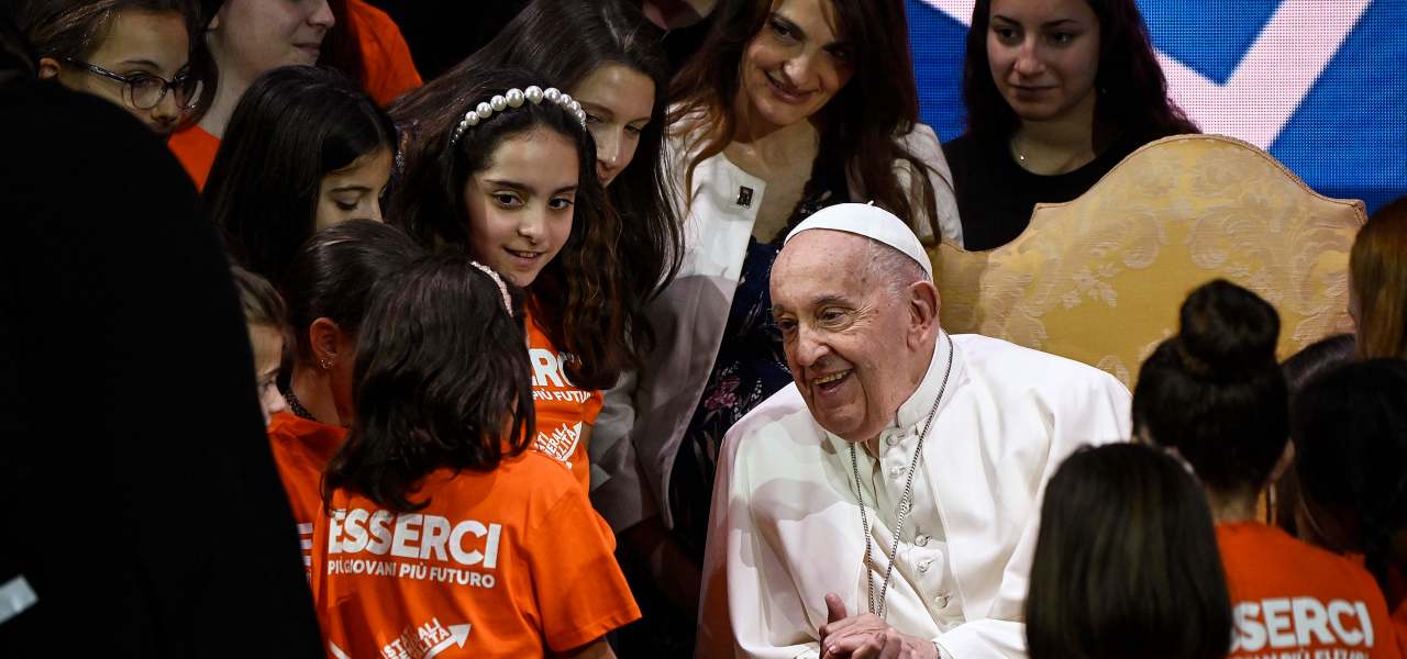 Papa Francesco parla con alcune bambine agli Stati generali della natalità (Ansa)