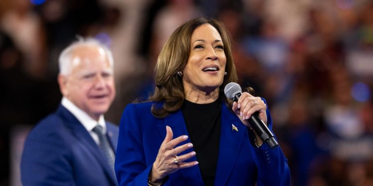 Kamala Harris, dietro di lei Tim Walz (Ansa)