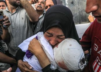 Una madre stringe il figlio dopo l'attacco israeliano all'Ospedale da campo al Aqsa a Gaza (Ansa)